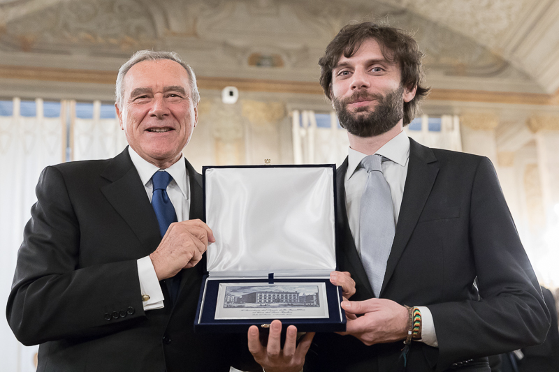 Il Presidente del Senato, Pietro Grasso, premia il direttore del Coro Keplero, Ludovico Versino.